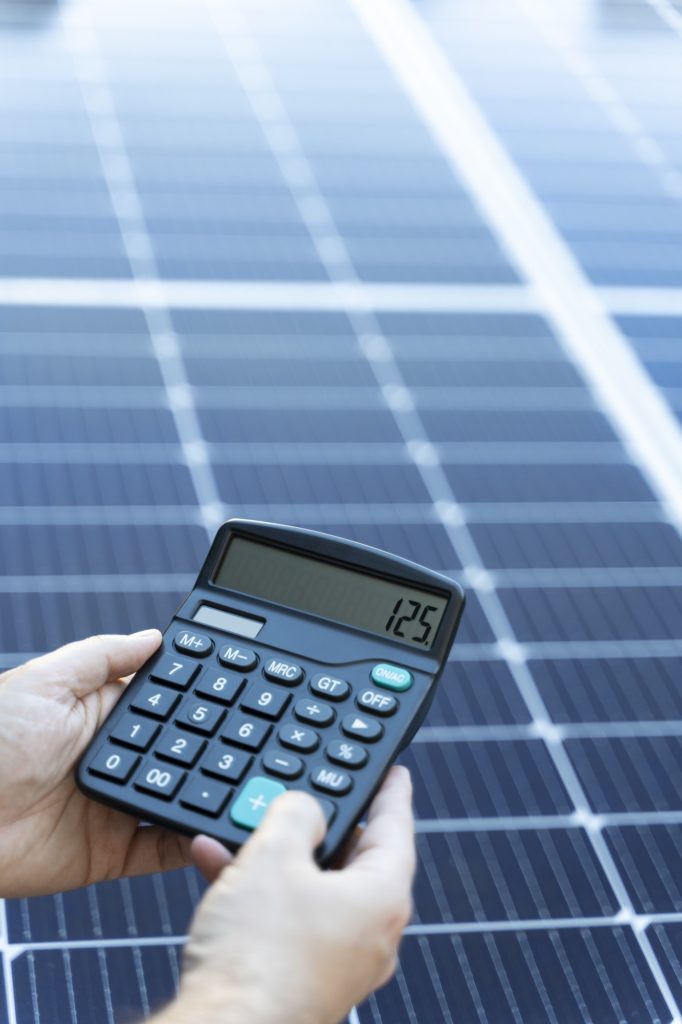 Energy saving concept with solar panels and a calculator
