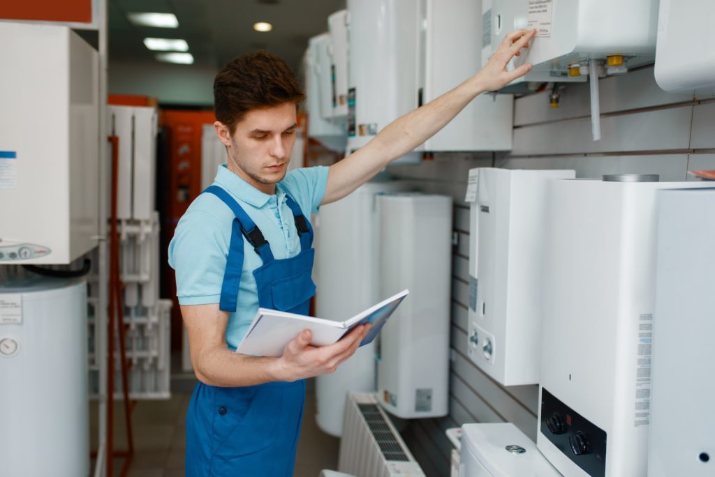 Plumber choosing boiler in plumbering store